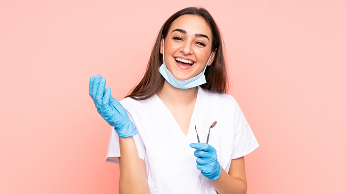 Woman Dentist Holding Tools Isolated On Pink Background Laughing