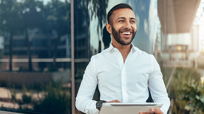 Portrait Of A Young Confident Smiling Indian Man Holding A Table